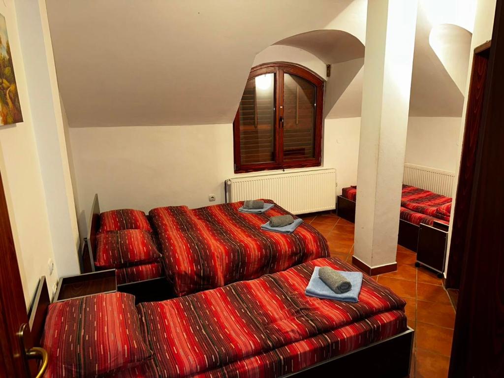 two beds in a room with red blankets at Vila Dukat Stara Planina in Crni Vrh