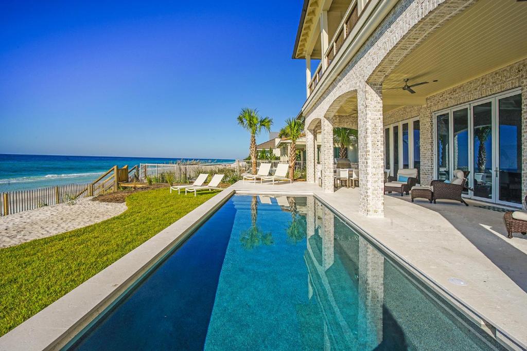 a house with a swimming pool next to the beach at 408 Blue Mountain in Santa Rosa Beach