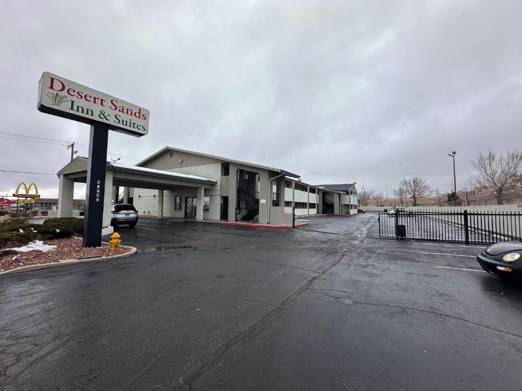 un edificio con un letrero para una posada y suites de arena del desierto en Desert Sands Inn & Suites, en Albuquerque