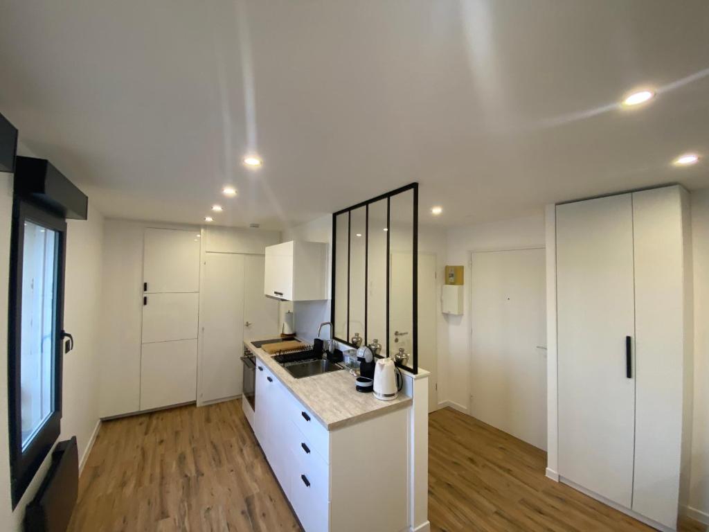 a kitchen with white cabinets and a counter top at Bali suites - Basel / Dreilander in Saint-Louis