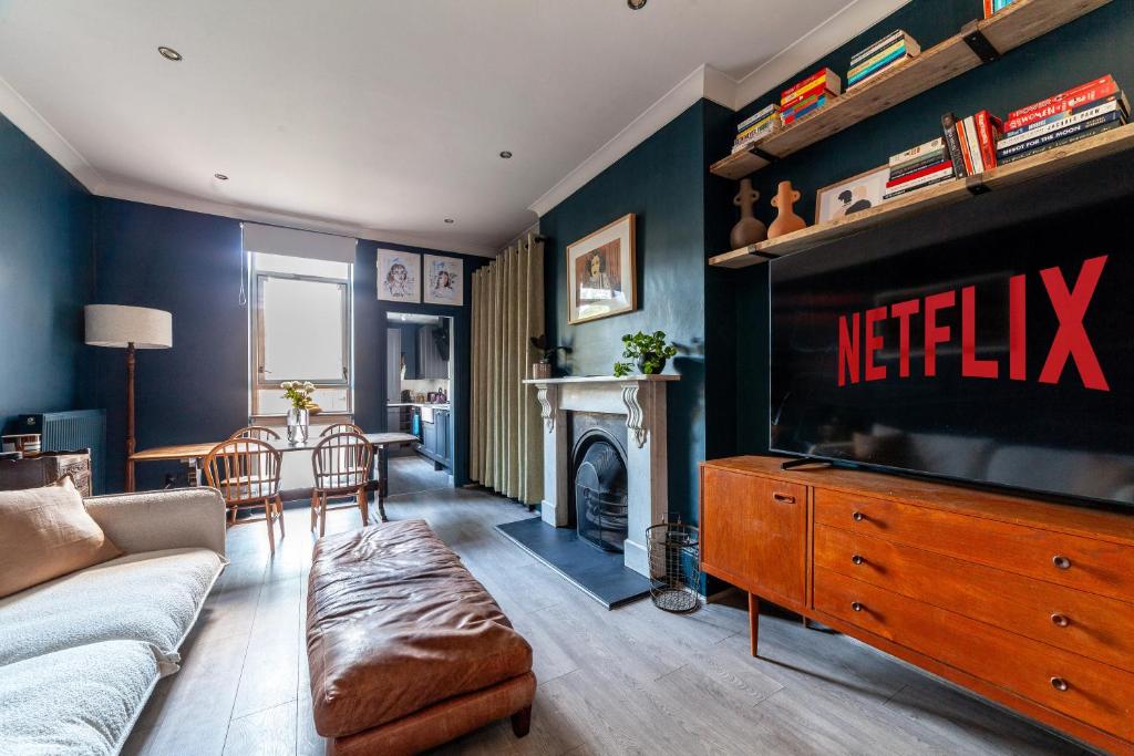 a living room with a couch and a tv and a table at Arte Stays - 2 Bed Luxurious Flat, Garden, 5min Dalston st., Parking Available, Serviced Accommodation - up to 5 ppl in London