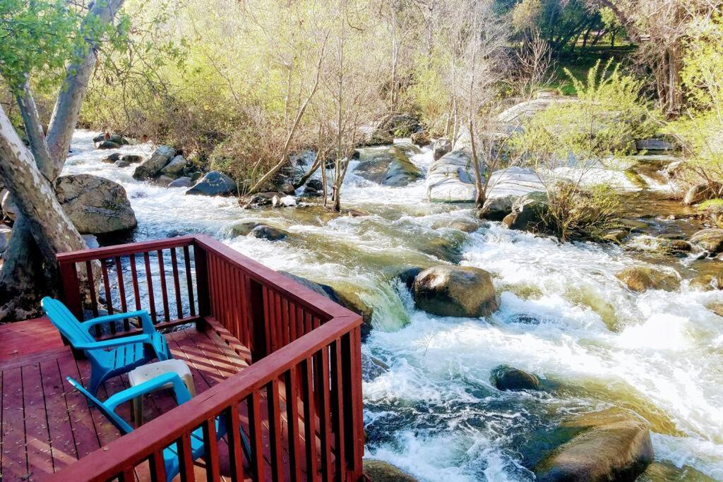 twee stoelen op een terras met uitzicht op een rivier bij River Retreat Cabin in Three Rivers - near SNP in Three Rivers