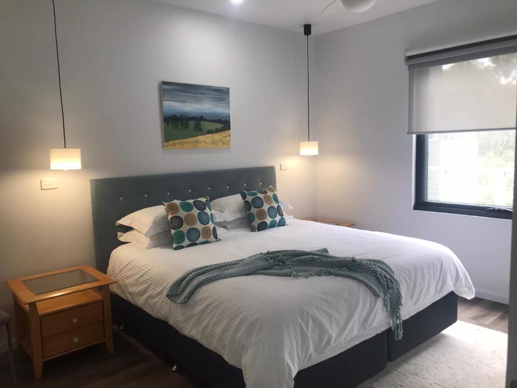 um quarto com uma cama grande com almofadas em Gillys Guesthouse em Metung