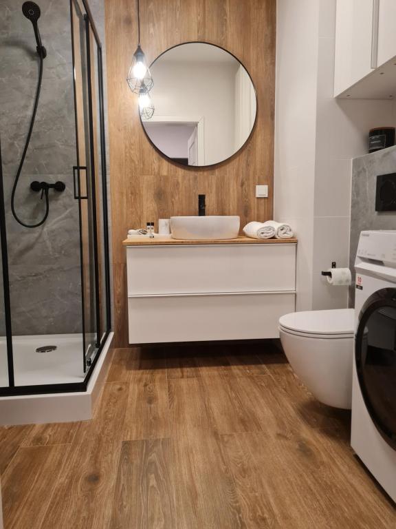 La salle de bains est pourvue de toilettes, d'un lavabo et d'une douche. dans l'établissement Chopin airport Apartment, à Varsovie