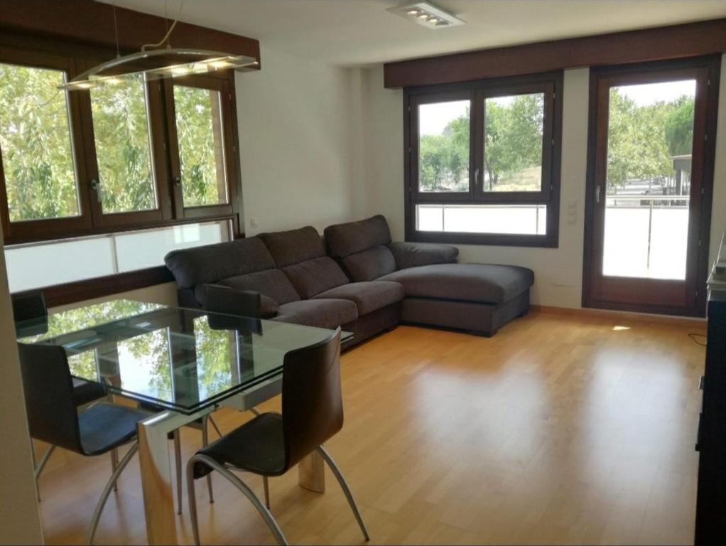 een woonkamer met een bank en een glazen tafel bij Habitacion con Piscina y Sauna in Sant Cugat del Vallès
