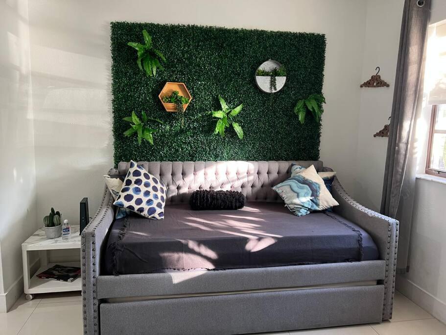 a bedroom with a bed with a green wall at Modern apartment steps the beach in Miami Beach