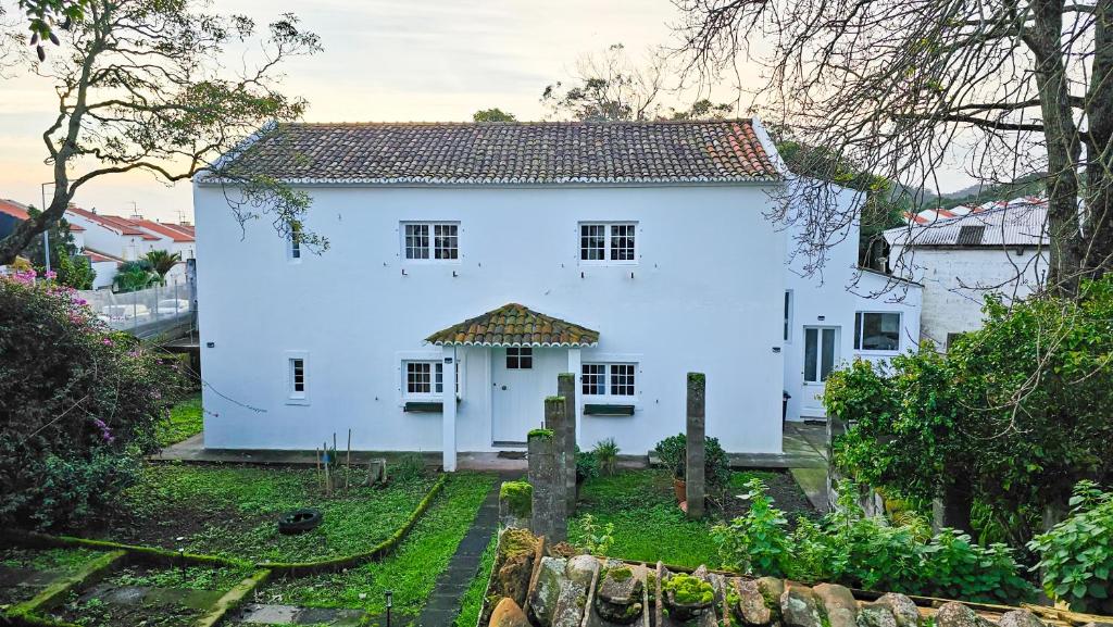 een wit huis met een tuin ervoor bij Casa da Abelheira in Ponta Delgada