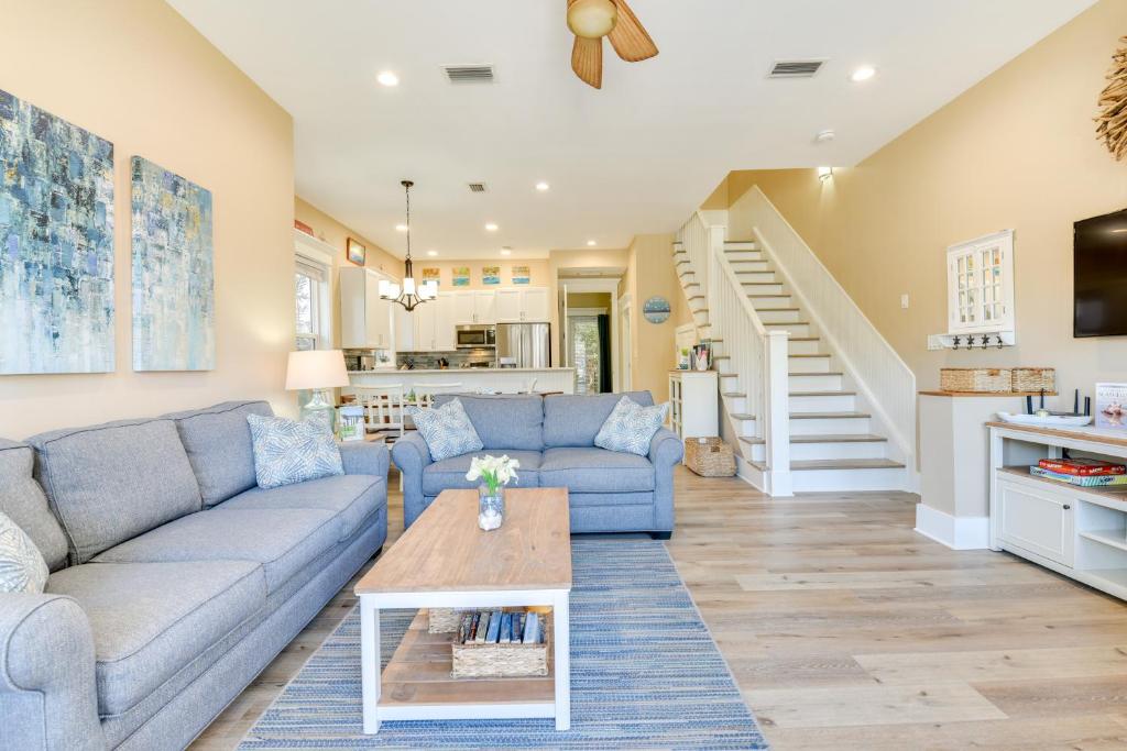 a living room with a blue couch and a table at Bright and Modern Townhome Steps to Miramar Beach! in Destin