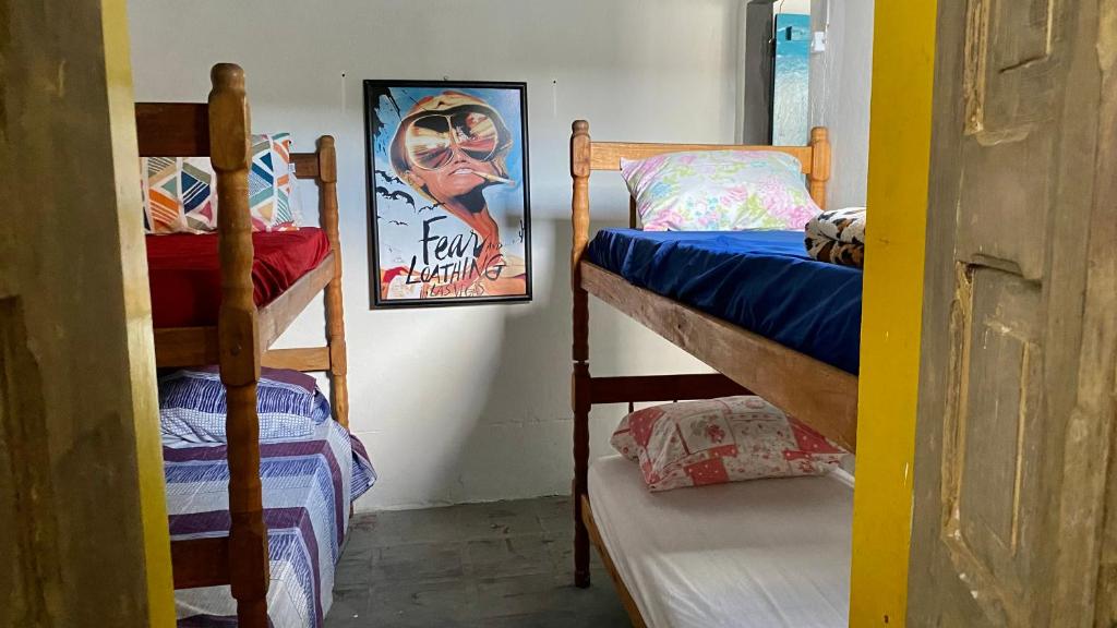 a room with two bunk beds and a picture at Casa Lee Hostel in Paraty