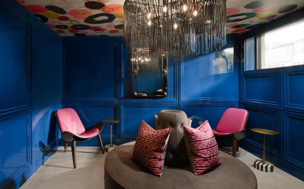 a blue room with pink chairs and a couch at Le Parc at Melrose in Los Angeles
