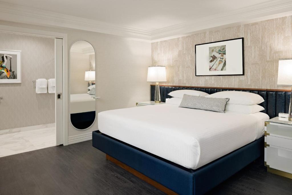 a bedroom with a large bed and a bathroom at Le Parc at Melrose in Los Angeles