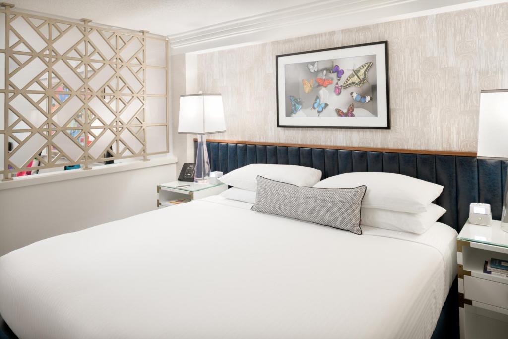 a bedroom with a large white bed and two lamps at Le Parc at Melrose in Los Angeles