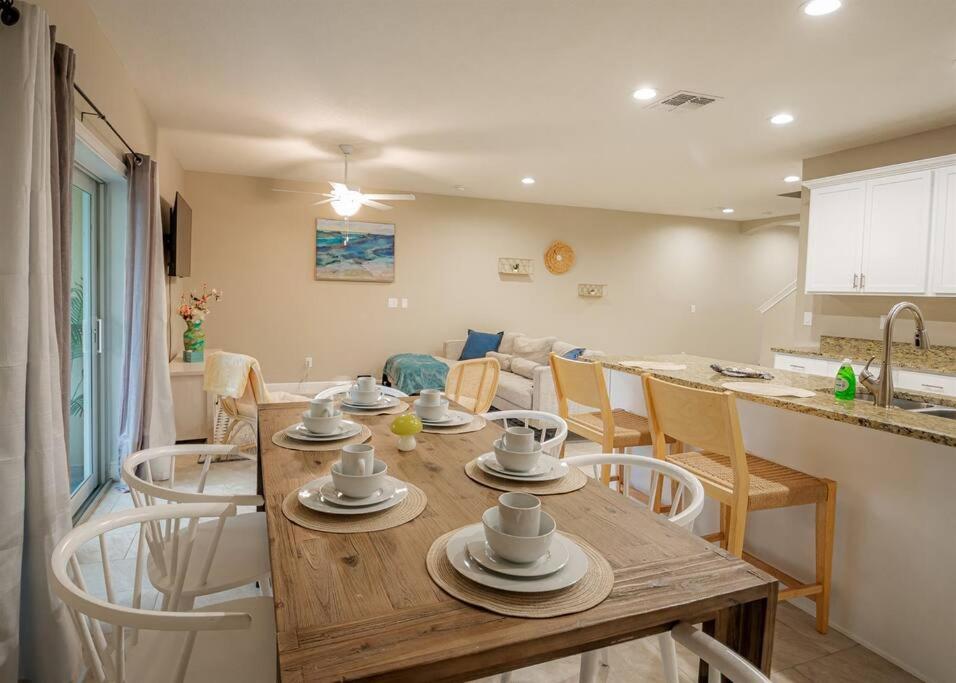 a kitchen and dining room with a wooden table and chairs at Beach Bliss - 5 MIN WALK to BEACH - Family Retreat in Daytona Beach Shores