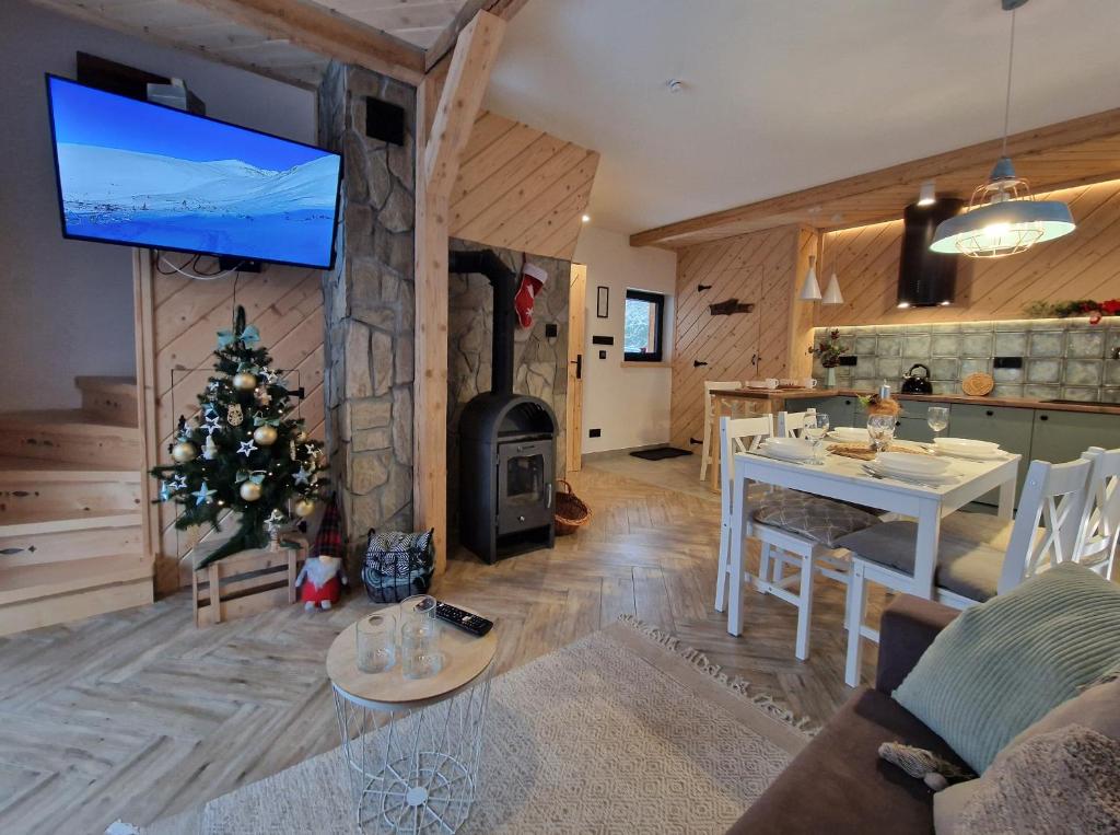 un salon avec un arbre de Noël et une cheminée dans l'établissement FILIPOWE CHATY, à Kościelisko