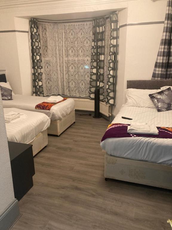 1 dormitorio con 2 camas y ventana en Abingdon Lodge Hotel, en Ryde