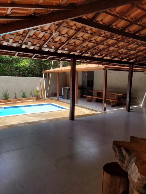 an outdoor patio with a pool and a pergola at Casa do Fábio in Santana do Riacho