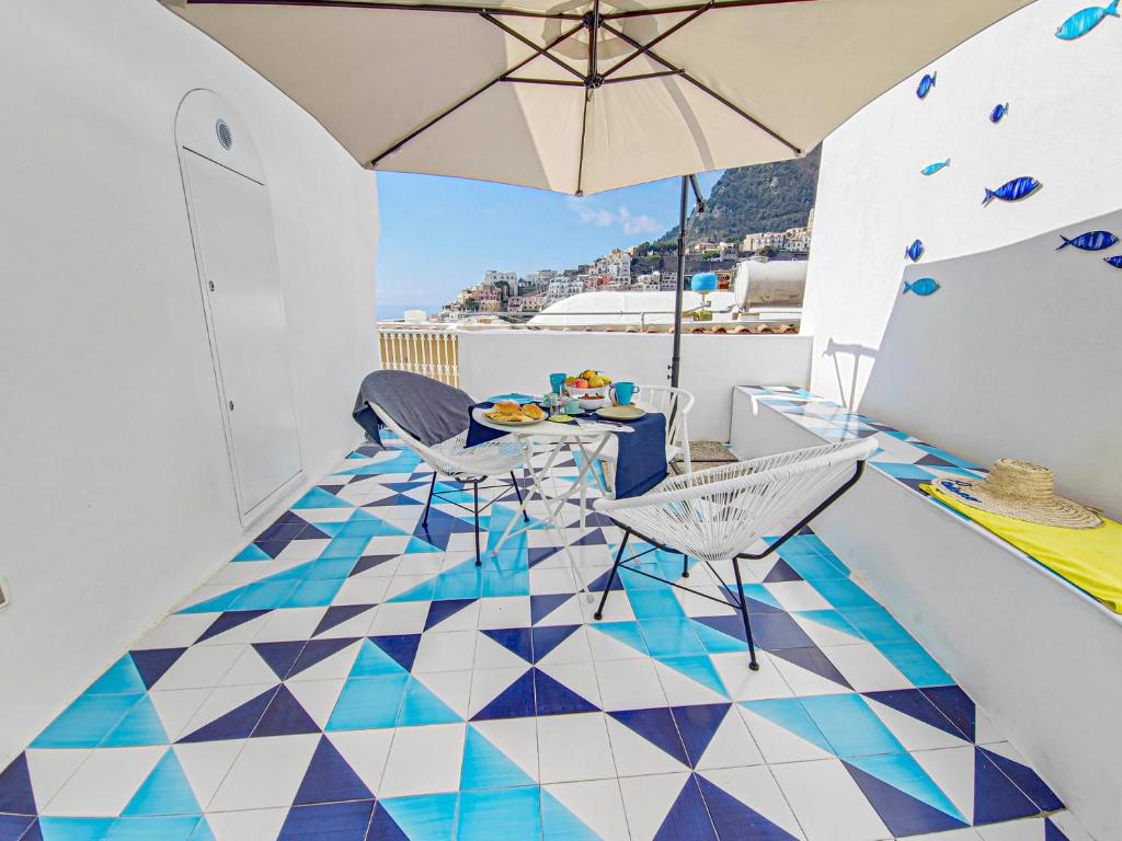 a balcony with a table and chairs and an umbrella at La Pigolina Blue in Positano