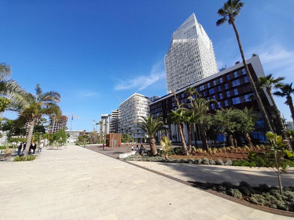 a city street with palm trees and a tall building at DOWNTOWN LIVING in Casablanca