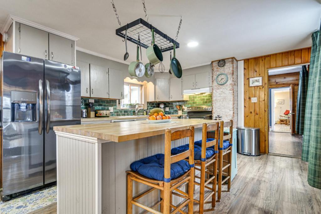 a kitchen with a island with bar stools at Charming Wilton Vacation Rental with Fire Pit in Wilton