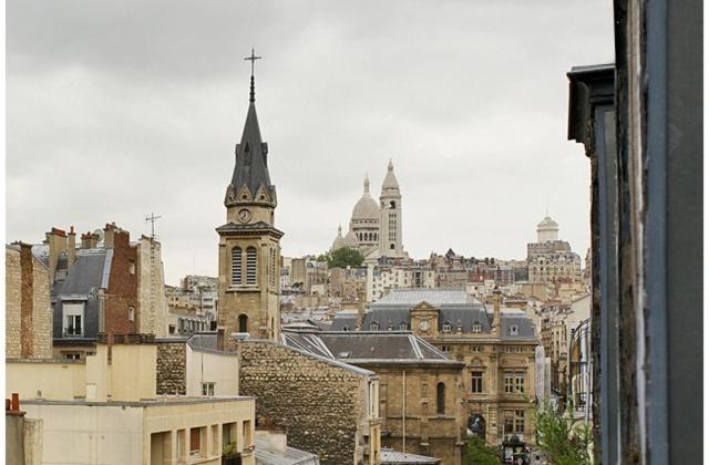 a view of a city with a clock tower at APPARTEMENT QUARTIER MONTMARTRE in Paris