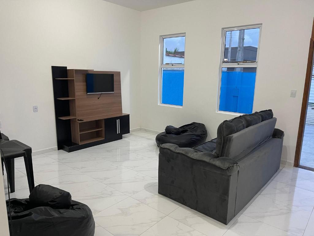 ein Wohnzimmer mit einem Sofa und einem TV in der Unterkunft Casa nova e móveis novos in Caraguatatuba