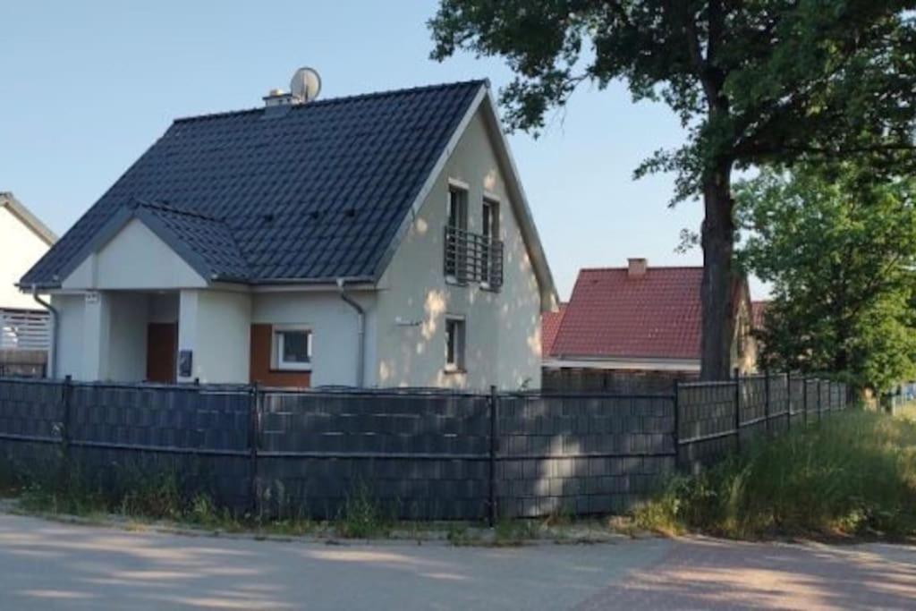 una casa blanca con techo negro y valla en Biały Dom en Łagów
