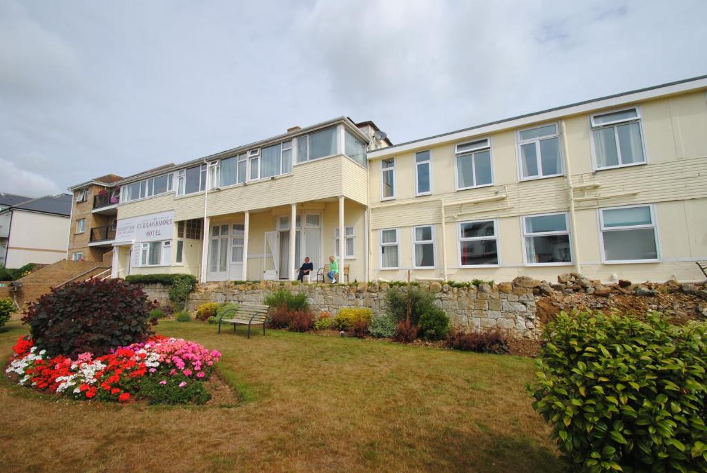 ein großes Gebäude mit Blumen im Hof in der Unterkunft The Curraghmore in Shanklin