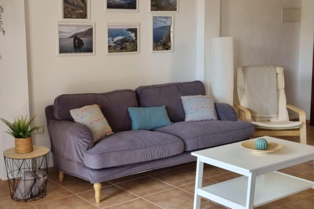 sala de estar con sofá púrpura y mesa en La Casita de Ari en Frontera