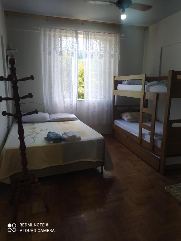 Un dormitorio con dos literas y una ventana. en kitnet aconchegante Miguel Pereira, en Miguel Pereira