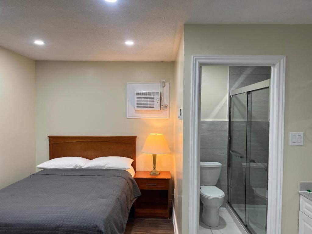 a bedroom with a bed and a walk in shower at Cedar Springs Motel in Acton