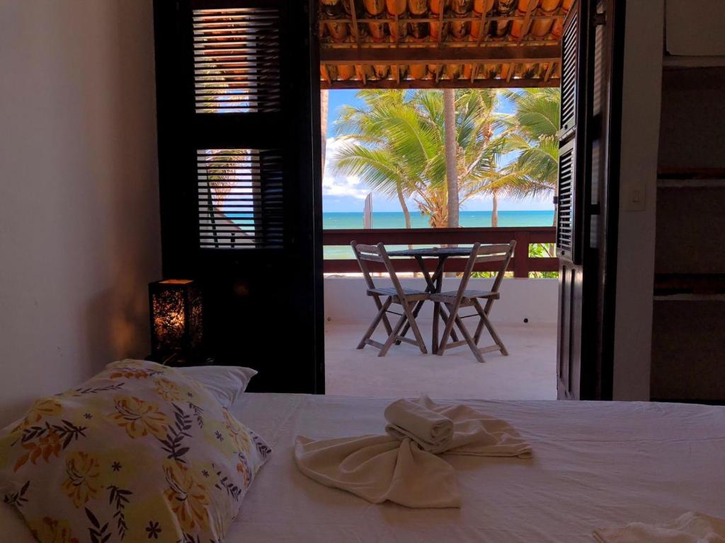 a bedroom with a bed with a view of the beach at ITACUPA - Healthy VEGAN & FOIL Center in Cumbuco