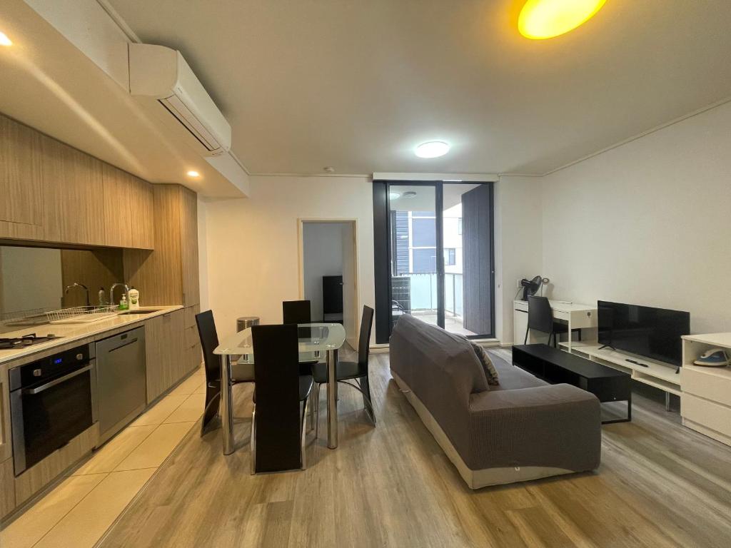 eine Küche und ein Wohnzimmer mit Tisch und Stühlen in der Unterkunft Entire 2 bedrooms Security Apartment in Riverwood