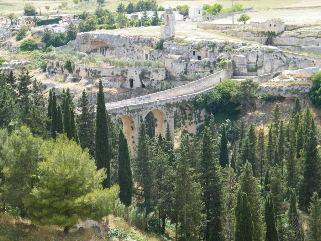 a bridge over a mountain with trees and a town at Relais Peucetia in Gravina in Puglia