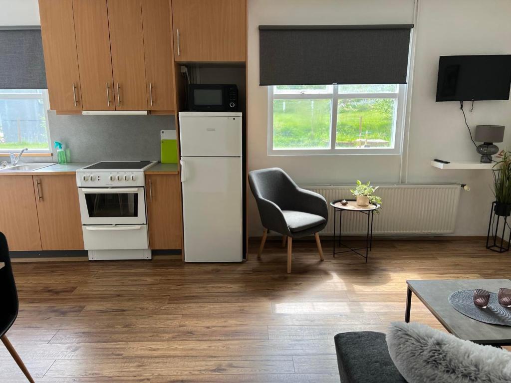 eine Küche mit einem weißen Kühlschrank und einem Tisch in der Unterkunft Lakeside Apartments in Egilsstaðir