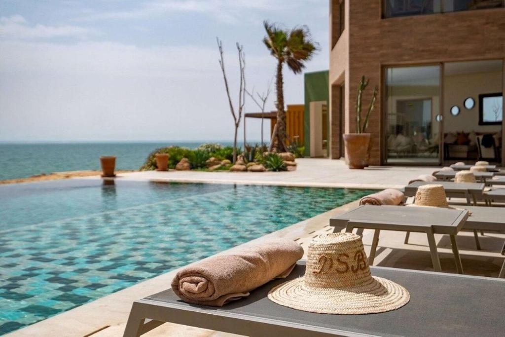 una piscina con toallas en una mesa junto al océano en Dakhla South Bay, en Dakhla