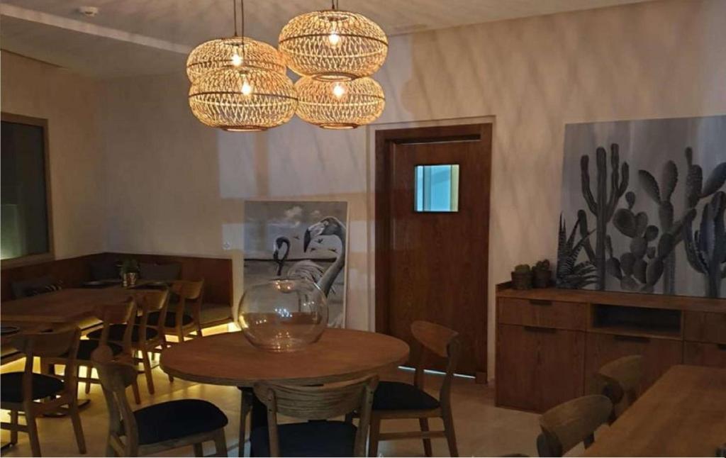 a restaurant with wooden tables and chairs and chandeliers at Dakhla South Bay in Dakhla