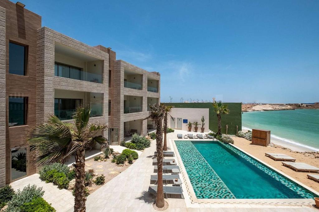 a building with a swimming pool next to the ocean at Dakhla South Bay in Dakhla