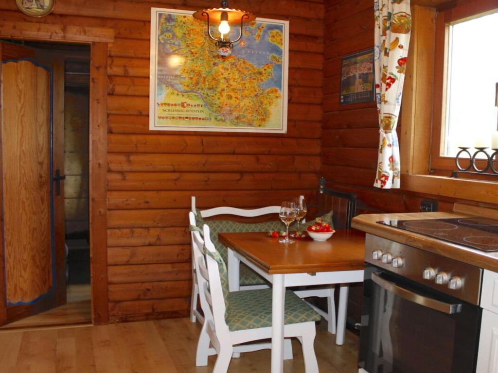 uma cozinha com uma mesa e cadeiras, uma mesa e um mapa em Holiday home Schleiblick em Gunneby