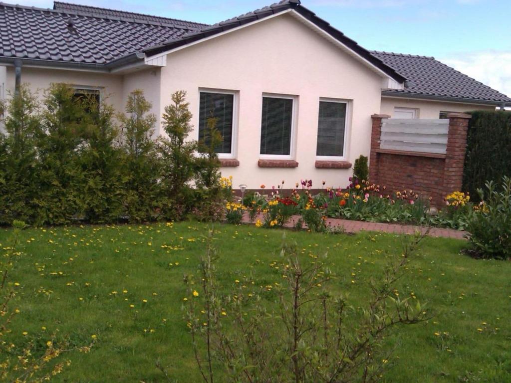 una casa con un césped verde delante de ella en 2 Zierow on the Baltic Sea, en Zierow