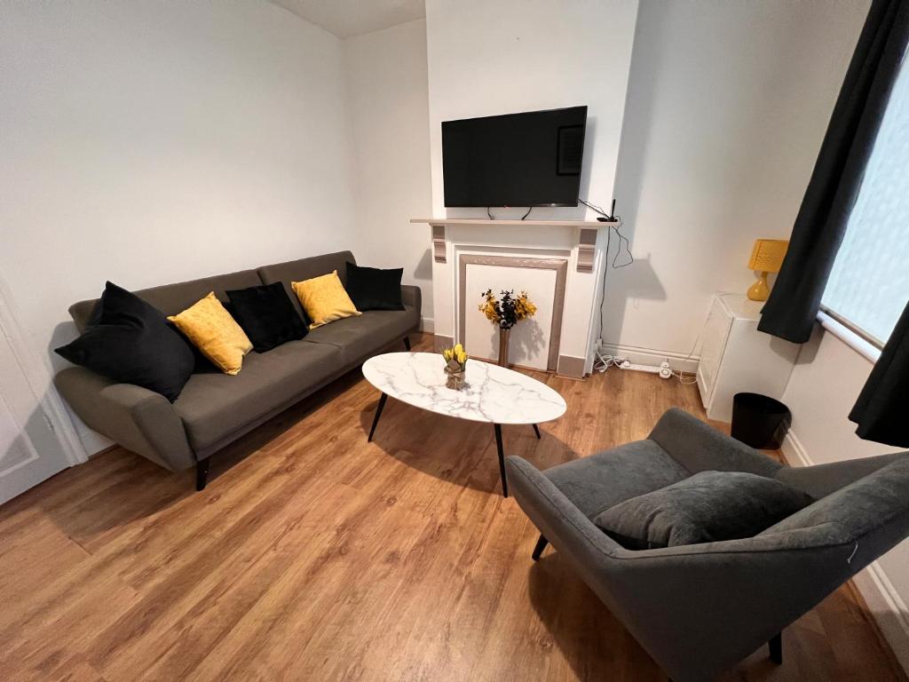 uma sala de estar com um sofá e uma mesa em Visit Luton With This 2 BR Rental - Sleeps 6 em Luton