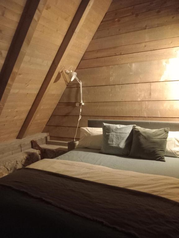 a bedroom with a bed with a wooden wall at ZlatAir Twins in Nova Varoš
