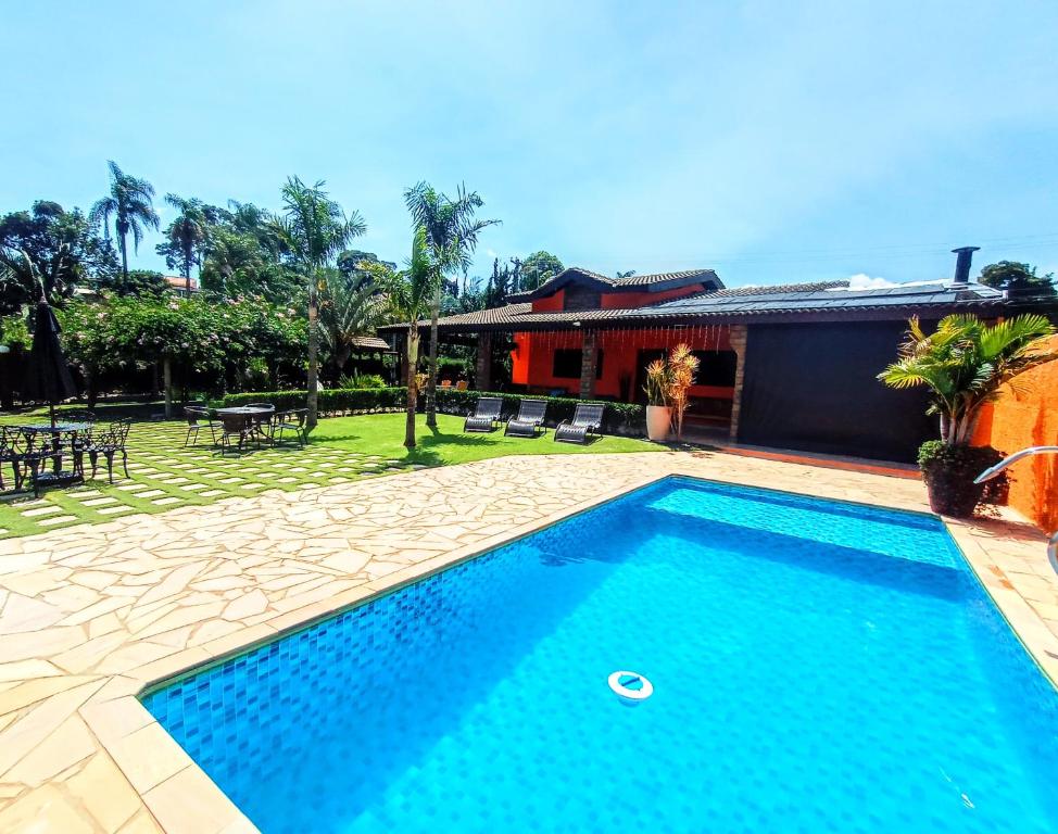 a swimming pool in front of a house at CHÁCARA BARBOSA II in Socorro