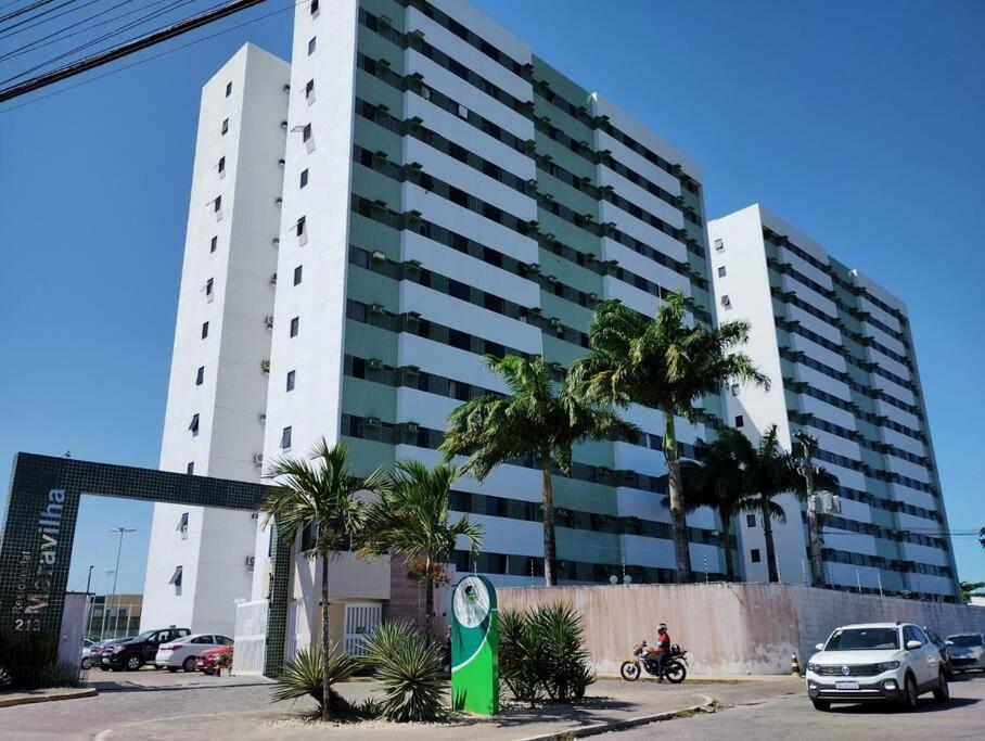 duży biały budynek z palmami przed nim w obiekcie Apto 6 min da praia da Pajuçara w mieście Maceió