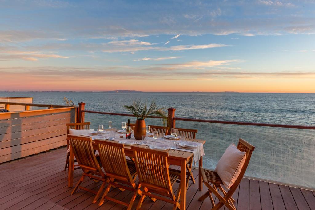 una mesa en una terraza con vistas al océano en Blue Dolphin: An Oceanfront Malibu Sanctuary en Malibu