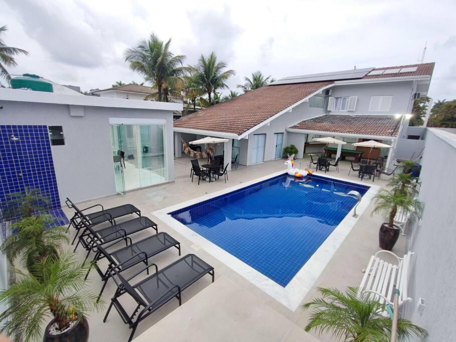 a swimming pool in the backyard of a house at Belissima casa Jardim Acapulco in Guarujá