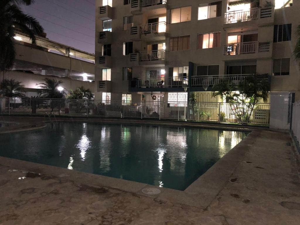 een zwembad voor een gebouw 's nachts bij cómodo apartamento 3 alcobas in Barranquilla