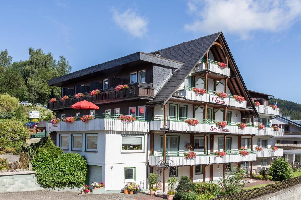 a large white building with flowers on the balconies at Gästehaus Behle-Schäperken in Willingen