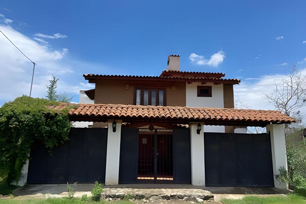 dom z czarnym płotem przed nim w obiekcie Cabaña Bechamel, Tapalpa w mieście Tapalpa