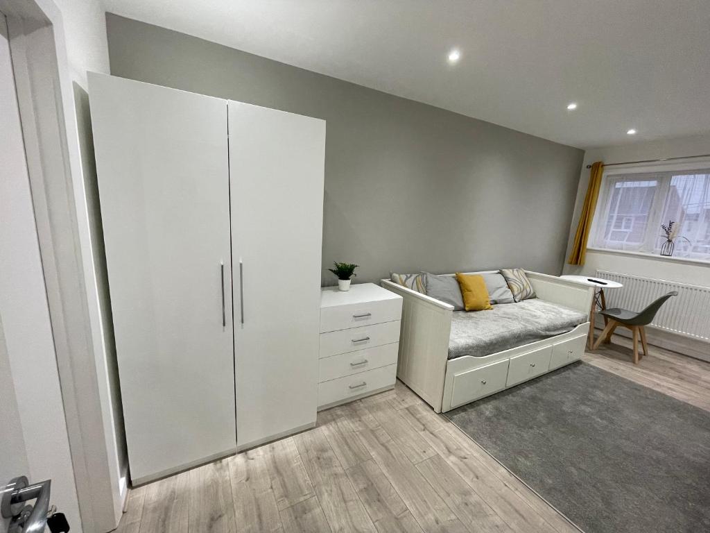 1 dormitorio con 1 cama y armario blanco grande en Garden Close Suites, en Ashford