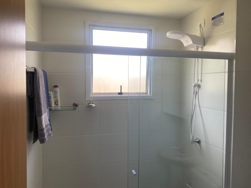 La salle de bains est pourvue d'une douche et d'une fenêtre. dans l'établissement Apartamento Lindo e Aconchegante, à São José